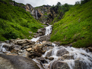 Fototapeta na wymiar Charming scenery of waterfalls and picturesque meadows of Alps in National park Hohe Tauern near Kaprun, Austria, Europe.