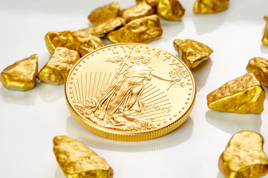 golden american eagle one ounce coin laying on a heap of golden nuggets, golden ore