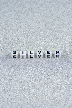 silver word formed by white dices with black letters  laying on silver background.
