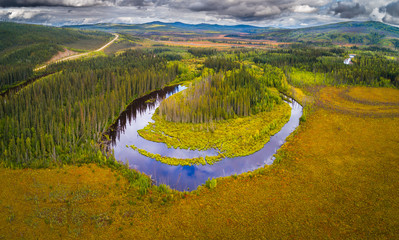 Aerial view of taiga landscape along the Dalton highway in Alaska. In the background the transAlaska pipeline and the Dalton highway are visible