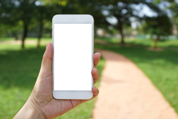 Close up adult hand holding a blank screen smartphone in the park