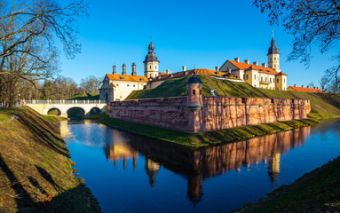 Fototapeta premium View of historic fortified Nesvizh Castle, landscape park and ponds on sunny winter day, Belarus