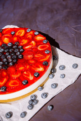 Creamy mascarpone cheese cake with strawberries and blueberries. Homemade Cheesecake. Close up. Healthy food. Creative atmospheric decoration.