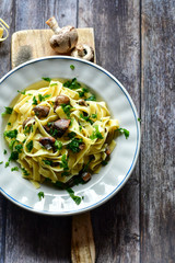 Italian food . Fresh home made  tagliatelle vegetarian  egg pasta  with mushrooms ,parmesan cheese ,fresh parsley  and black pepper.