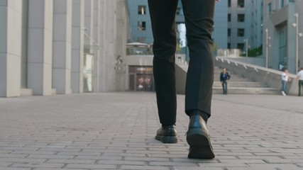 Portrait of Confident Bearded Businessman in Suit Walking Downtown on Streets of Business District. Confident business man goes to work in a modern office building.
