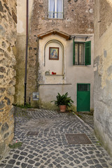 Fototapeta na wymiar A small street between the old houses of Giuliano di Roma, of a medieval village in the Lazio region, Italy.