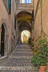 Fototapeta na wymiar A small street between the old houses of Giuliano di Roma, of a medieval village in the Lazio region, Italy. 