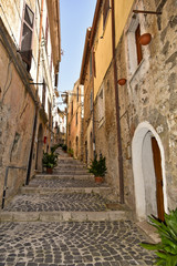 Fototapeta na wymiar A small street between the old houses of Giuliano di Roma, of a medieval village in the Lazio region, Italy. 