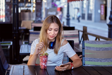 Young white woman in street cafe.