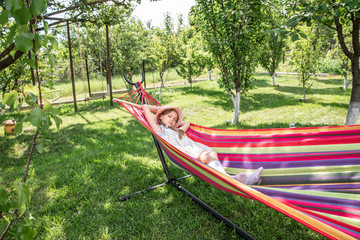 a little girl lying in a hammock on the street in the park