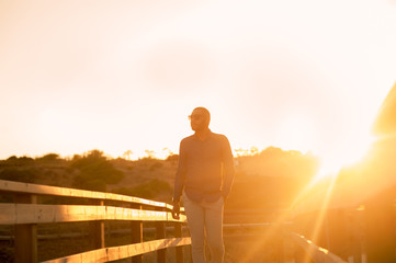 Happy latin man walking and enjoying the sunset with a natural landscape view