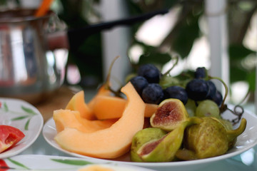 Plate with various fruit on a table in a garden. Selective focus.