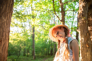 little cute girl in a hat. a child in a beautiful magical forest.