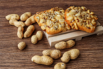 Homemade crispy vegan gluten-free cookies with peanuts, flax seeds, sunflower seeds and pumpkin. whole peanuts on a wooden table Stack of cookies.