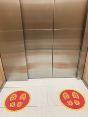 Social distance signs on the floor in the elevator