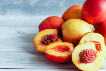 Fototapeta na wymiar Sweet ripe juicy fruit, nectarines on a light wooden background on a cutting Board