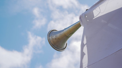 A loudspeaker against a clean blue sky.