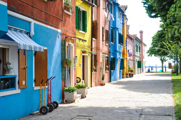 Fototapeta na wymiar View of a narrow street in Burano in Italy. Beautiful colorful houses in sunny weather.
