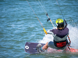 A kitesurfer glides on the water at full speed