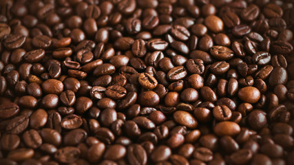 The background shows a lot of roasted natural aromatic coffee beans, which will make a strong invigorating espresso.