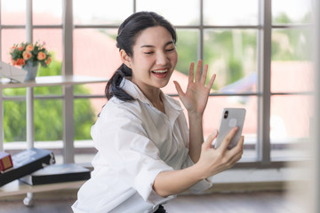 Obraz premium Young Asian women are using laptops and smart phone to study online, work from home, and transact online during the coronavirus outbreak.