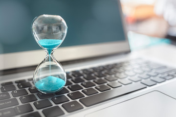 Fototapeta Hourglass on laptop computer concept for time management obraz