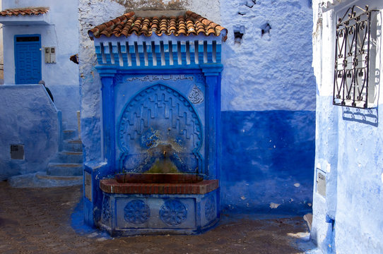 Ancient public water fountain in the blue painted medina, Chefchaouen, Morocco