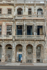 Obraz premium old facade, with boy leaning on the column in Havana