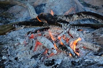 The charcoals of the bonfire are quietly smoldering.