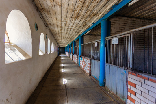 Old historical horse stable with loose horse boxes, tunnel view