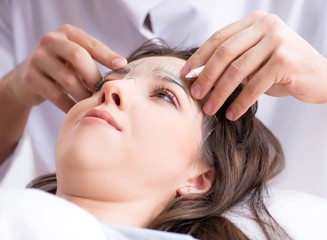 Naklejka premium Doctor measuring patient's face before plastic surgery
