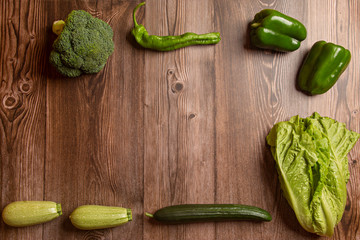 Green vegetables viewed from above on wooden background.