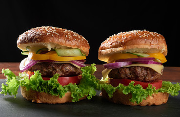 delicious burgers with fried beef cutlet, tomato, lettuce and onions, crispy white wheat flour bun with sesame seeds