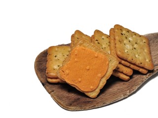 Sandwich crackers with cheese cream on wooden board