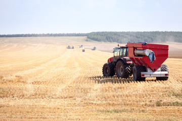 Obraz premium Panoramic view at combine harvesters working on a wheat field. Harvesting the wheat. Agriculture machinery.
