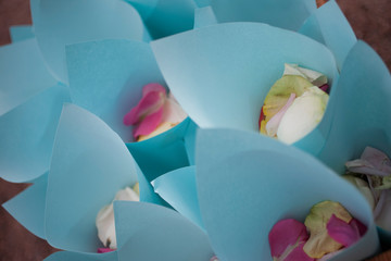 Blue paper bags with rose petals.