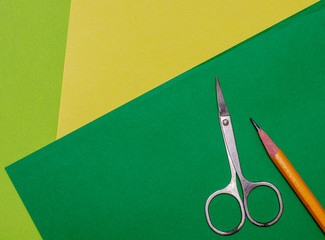 pencil and scissors on a green background back to school