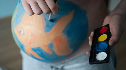 Naklejka premium Pregnant Woman With Body-Art Of Fish On Her Belly