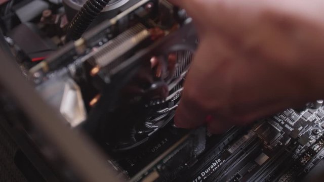 IT technician install a graphic card into a PCIe slot of a desktop computer
