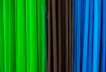 Abstract - green, blue, and brown stripes. Spines of colored plastic folders