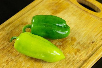 
green bell peppers on a wooden cutting board