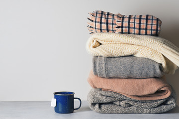 Autumn cozy and casual clothes stack close up on on white background