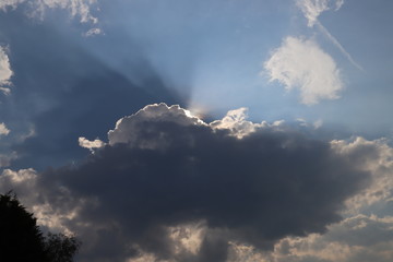Fototapeta na wymiar Crepuscular rays with Iridescence colors at a cumulus cloud