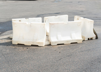 White plastic barrier blocks around the defect on the asphalt due the maintenance. High quality photo