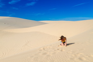 Woman sitting on the sand in the desert