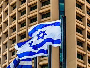 Israel flags on background of building in Tel Aviv Magen David sign, Israel independence day,...