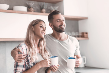 young couple drinking coffee standing in the kitchen