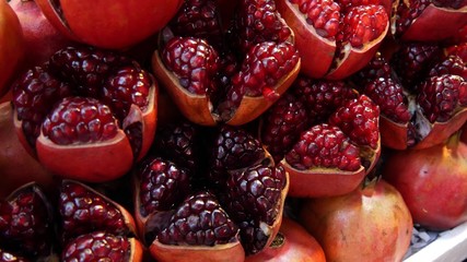 Halves of ripe pomegranates for juice. Heap of halves of yummy ripe pomegranates for fresh juice placed on stall