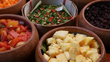 Top view of selection of various platters with delicious asian food and spices on a street market stall in Bangkok, Thailand.