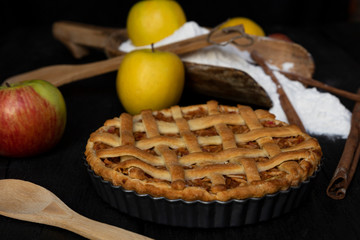 Homemade lattice Apple pie with cinnamon on an old textured wooden background